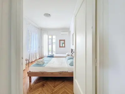 a living room with a table and chairs and a television at Promenade des Anglais GARDEN SEA VIEW in Nice