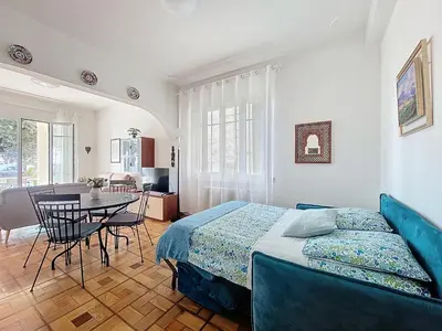 a living room with a couch and a table at Promenade des Anglais GARDEN SEA VIEW in Nice