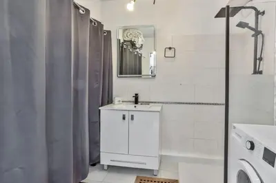 a white bathroom with a sink and a mirror at Heidi Braesch Apartment in Nice