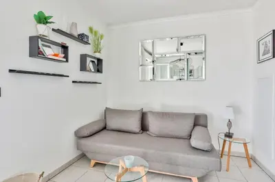 a living room with a couch and a mirror at Heidi Braesch Apartment in Nice