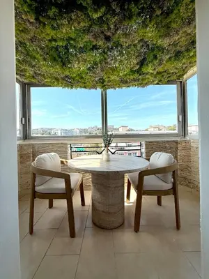 a table and chairs in a room with a large window at Beachfront Appartment Nice Promenade des anglais 2 terraces in Nice