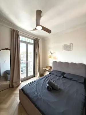 a bedroom with a large bed with a ceiling fan at Beachfront Appartment Nice Promenade des anglais 2 terraces in Nice
