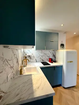 a kitchen with a white refrigerator and a sink at Beachfront Appartment Nice Promenade des anglais 2 terraces in Nice