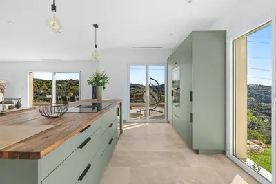 a kitchen with white cabinets and a large window at Happyfew Domaine des Sources in Nice