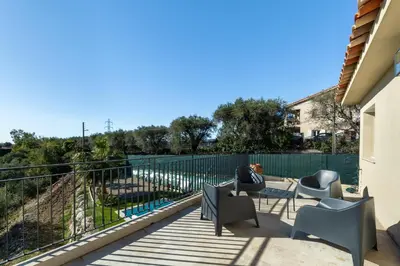 a patio with chairs and a table and a fence at Happyfew Domaine des Sources in Nice