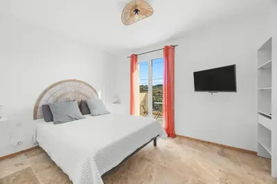 a white bedroom with a bed and a tv at Happyfew Domaine des Sources in Nice