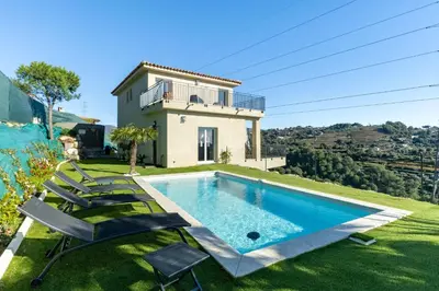 a villa with a swimming pool in front of a house at Happyfew Domaine des Sources in Nice