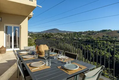 a dining table on the balcony of a house at Happyfew Domaine des Sources in Nice