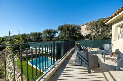 a balcony with a fence and a swimming pool at Happyfew Domaine des Sources in Nice