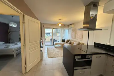a kitchen with a counter top and a living room at Cozy apartment in the heart of Nice in Nice
