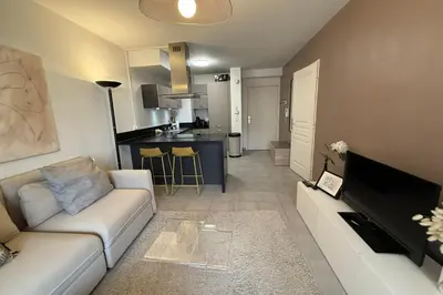 a living room with a couch and a kitchen at Cozy apartment in the heart of Nice in Nice