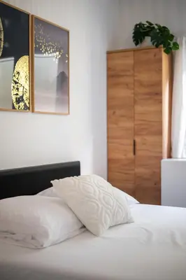 a bed with white sheets and a wooden cabinet at Modern Luxury - Sea View over Èze Village in Èze