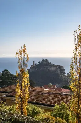 a castle sitting on top of a mountain with buildings at Modern Luxury - Sea View over Èze Village in Èze