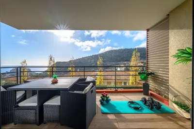 a balcony with a table and a view of the mountains at Modern Luxury - Sea View over Èze Village in Èze