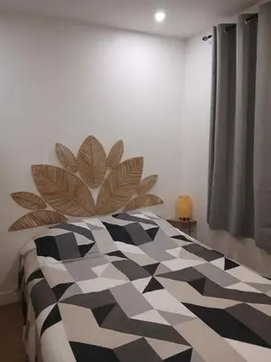 a bedroom with a black and white patterned bed at vacances au soleil in Cagnes-sur-Mer