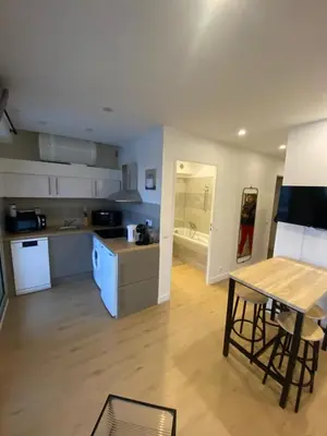 a kitchen and living room with a table and a counter at vacances au soleil in Cagnes-sur-Mer