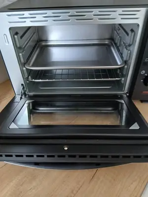 a toaster oven with its door open on a table at vacances au soleil in Cagnes-sur-Mer