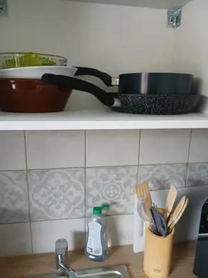 a pan sitting on a shelf above a kitchen sink at vacances au soleil in Cagnes-sur-Mer