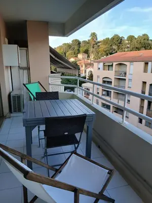 a balcony with a table and chairs and a laptop on it at vacances au soleil in Cagnes-sur-Mer
