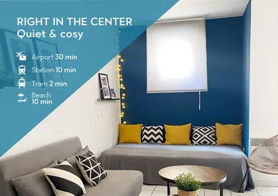 a couch in a room with a blue wall at Plein centre, calme et cosy in Nice