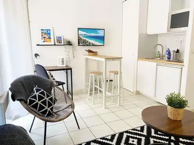a kitchen with a table and chairs in a room at Plein centre, calme et cosy in Nice