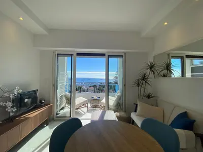 a living room with a table and a view of the ocean at mure in Beaulieu-sur-Mer