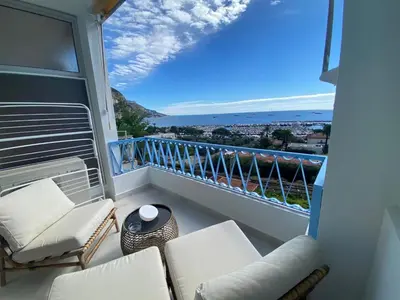 a balcony with white furniture and a view of the ocean at mure in Beaulieu-sur-Mer