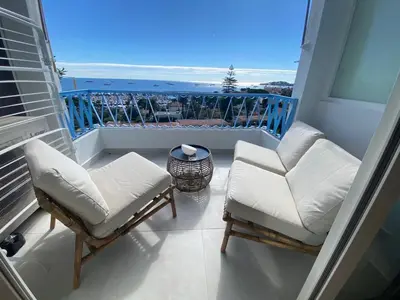 a balcony with two chairs and a view of the ocean at mure in Beaulieu-sur-Mer