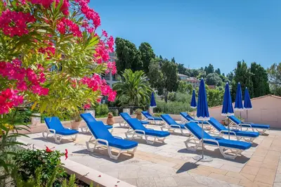 a row of blue lounge chairs and umbrellas at faucher in Villefranche-sur-Mer