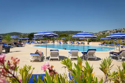 a swimming pool with lounge chairs and umbrellas at faucher in Villefranche-sur-Mer
