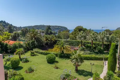 a view of a garden with palm trees and bushes at faucher in Villefranche-sur-Mer