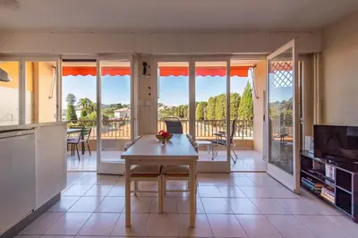 a kitchen with a table and a view of a balcony at fisher in Beaulieu-sur-Mer