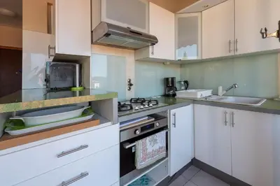 a kitchen with white cabinets and a sink at fisher in Beaulieu-sur-Mer