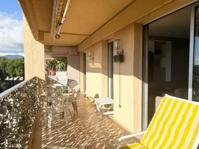 a balcony with a table and chairs on a building at 2 pièces cosy avec grande terrasse & piscine in Cagnes-sur-Mer