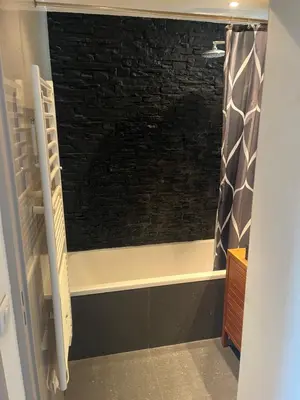 a bathroom with a window with a brick wall at 2 pièces cosy avec grande terrasse & piscine in Cagnes-sur-Mer