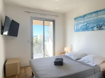 a bedroom with a bed with a television and a window at 2 pièces cosy avec grande terrasse & piscine in Cagnes-sur-Mer