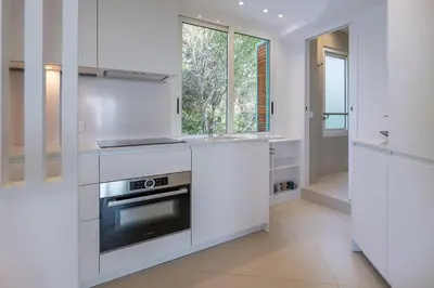 a kitchen with white cabinets and a stove at Ferreira in Saint-Jean-Cap-Ferrat