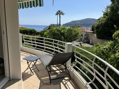 a balcony with a chair and a view of the ocean at Ferreira in Saint-Jean-Cap-Ferrat