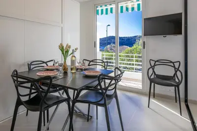 a dining room with a black table and chairs at Ferreira in Saint-Jean-Cap-Ferrat