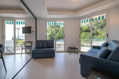 a living room with a couch and chairs and windows at Ferreira in Saint-Jean-Cap-Ferrat