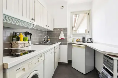 a white kitchen with a sink and a dishwasher at LX173 Studio grande terrasse vue mer tres calme in Nice