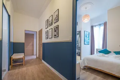 a bedroom with a bed and a blue wall at Chambre 4 La Nissa Bella in Nice