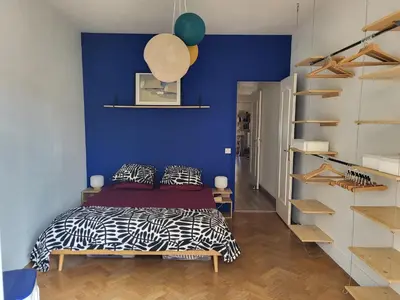 a bedroom with a bed and a blue wall at 2P cosy avec terrasse, vue mer & plages à pied in Nice