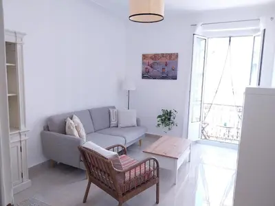 a living room with a couch and a table at Spacious apartment with balcony - Nice center in Nice