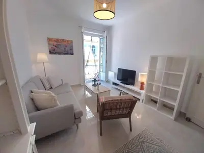 a living room with a couch and a table at Spacious apartment with balcony - Nice center in Nice