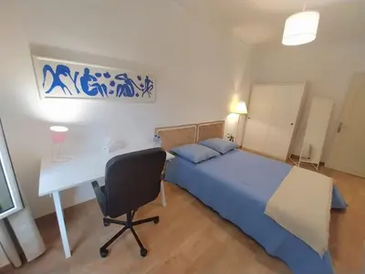 a bedroom with a bed and a desk and a bed and a chair at Spacious apartment with balcony - Nice center in Nice