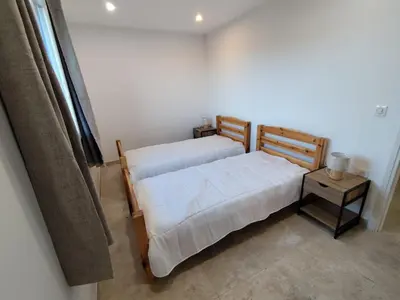 a bedroom with two beds and a side table at Gite Maïoun Cremat in Nice