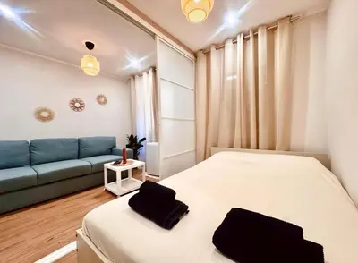 a bedroom with a bed and a blue couch at Cozy apartment in the heart of Nice - 3 to 4 people in Nice