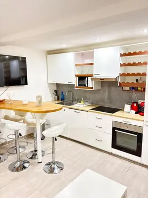 a kitchen with a wooden table and white cabinets at Elegant T2 Climatise Vieux Nice Garibaldi in Nice