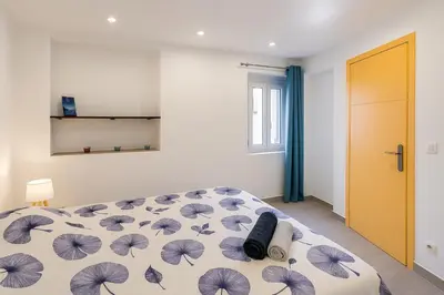 a bedroom with a bed with a blue and white comforter at Elegant T2 Climatise Vieux Nice Garibaldi in Nice